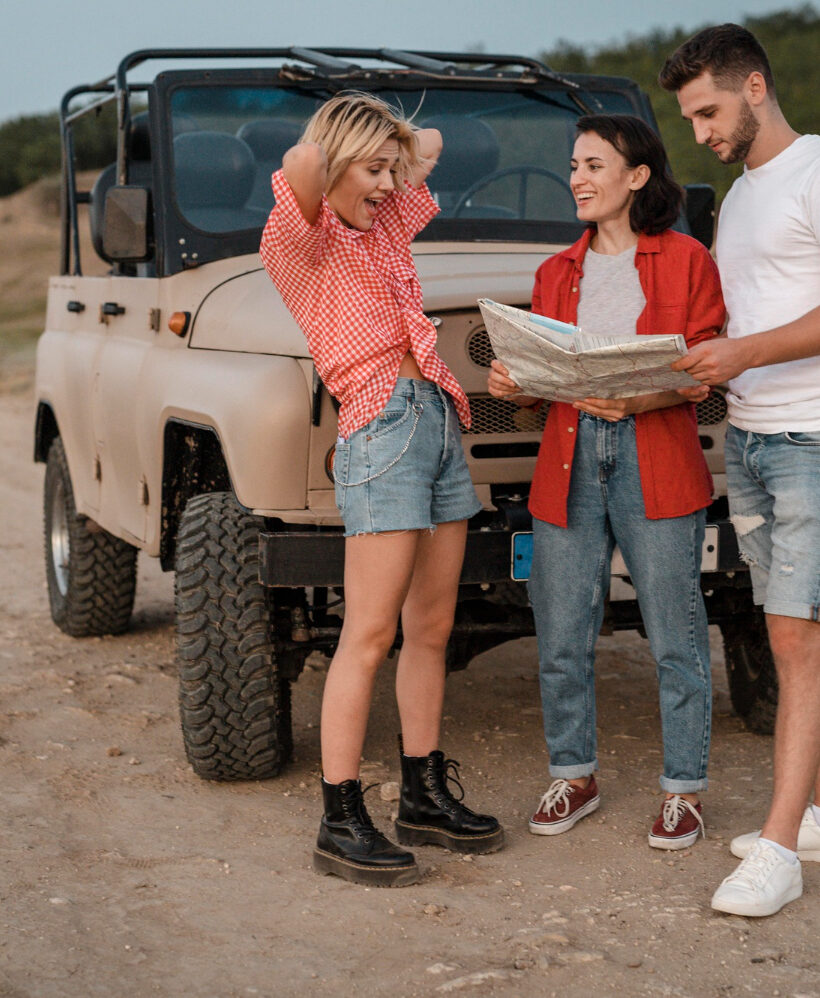 Zespół uczestników planujący trasę przy samochodzie terenowym podczas wyjazdu firmowego