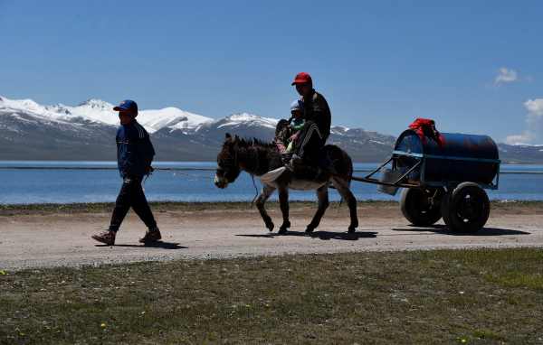 Mieszkańcy Kirgistanu z końmi i wózkiem nad górskim jeziorem podczas podróży Nomads