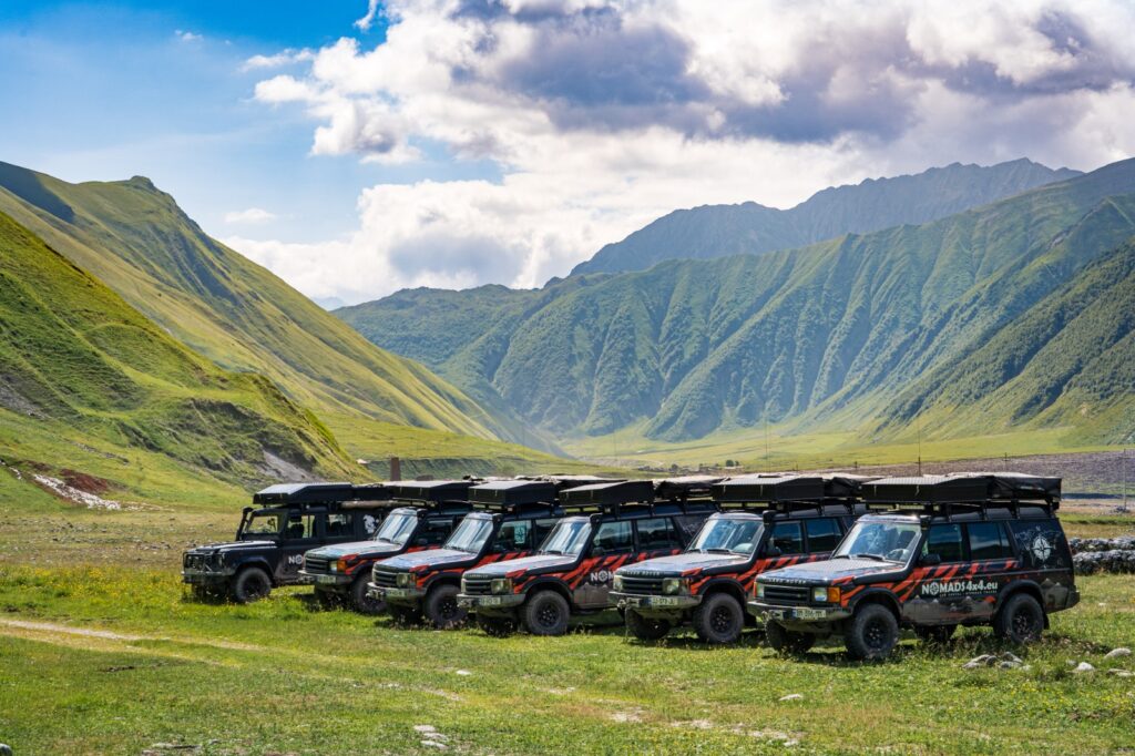 Na pierwszym planie auta terenowe Land Rover Discovery II w oddali widok na Dolinę Truso